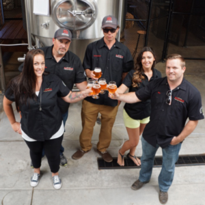 photo of the five company founders of revision brewing at the brewery in front of brewing mash ton